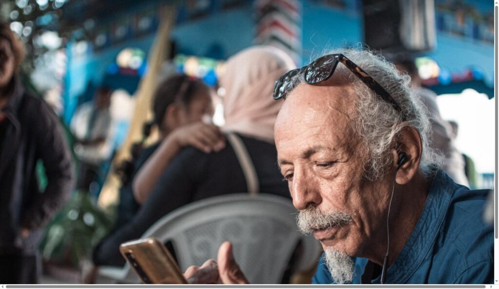 Elderly man reading text on his iPhone screen with enlarged font size