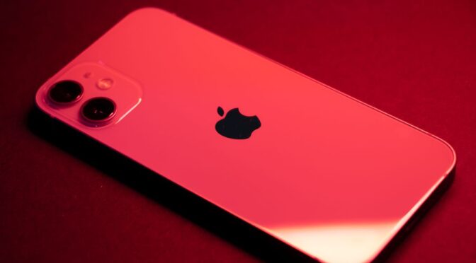 Close-up of iPhone in red finish showing rear camera module and Apple logo