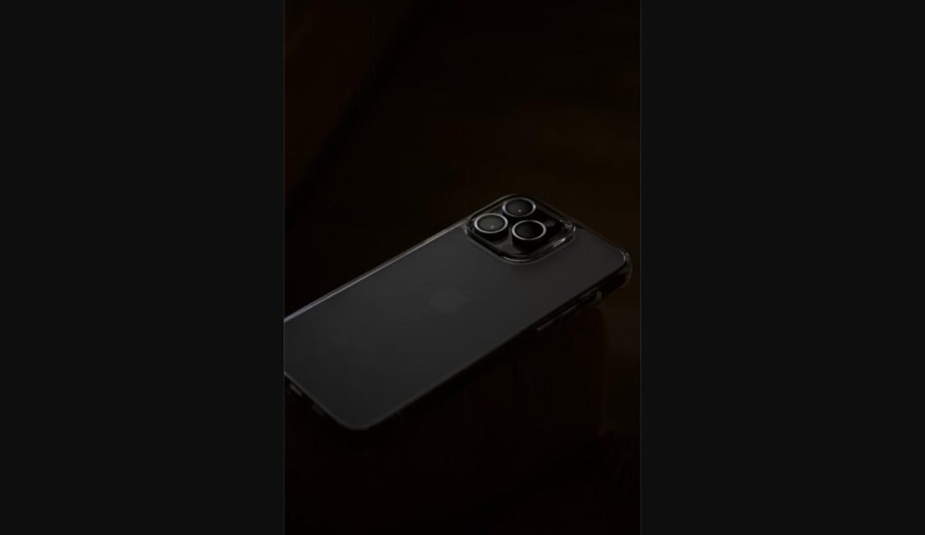 Close-up of a dark iPhone's triple camera lens on a dark background
